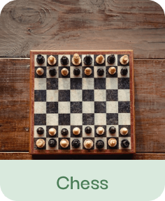 Chess board with pieces set up on wooden surface